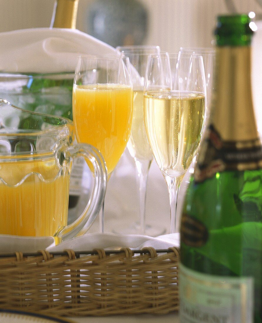 Glasses & bottles of champagne, glass & jug of orange juice