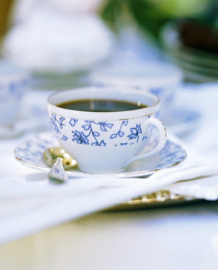 Black coffee in white china cup with blue pattern