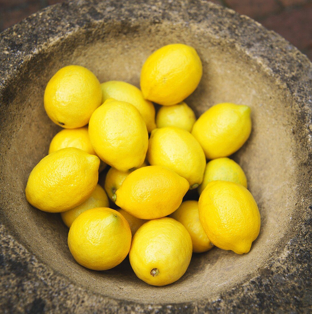 Viele Zitronen in rundem Steinbecken