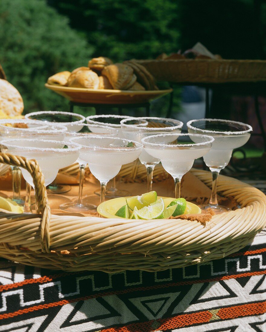 Mehrere Gläser mit Margarita-Cocktails auf Korbtablett