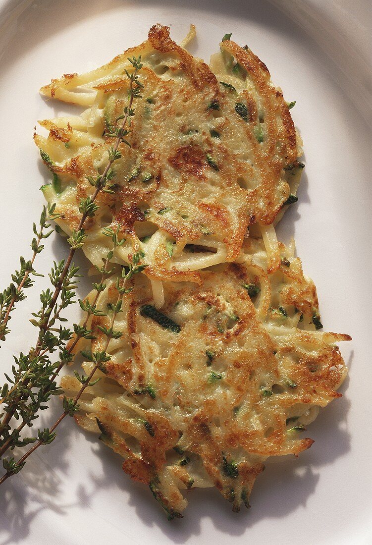 Potato rosti with grated courgettes and sprig of thyme