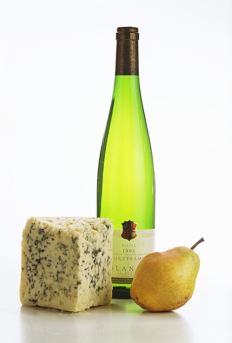 A piece of blue cheese, a pear and bottle of Gewürztraminer