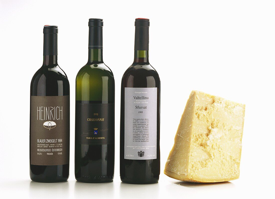 Piece of Parmesan and suitable red and white wine in bottles