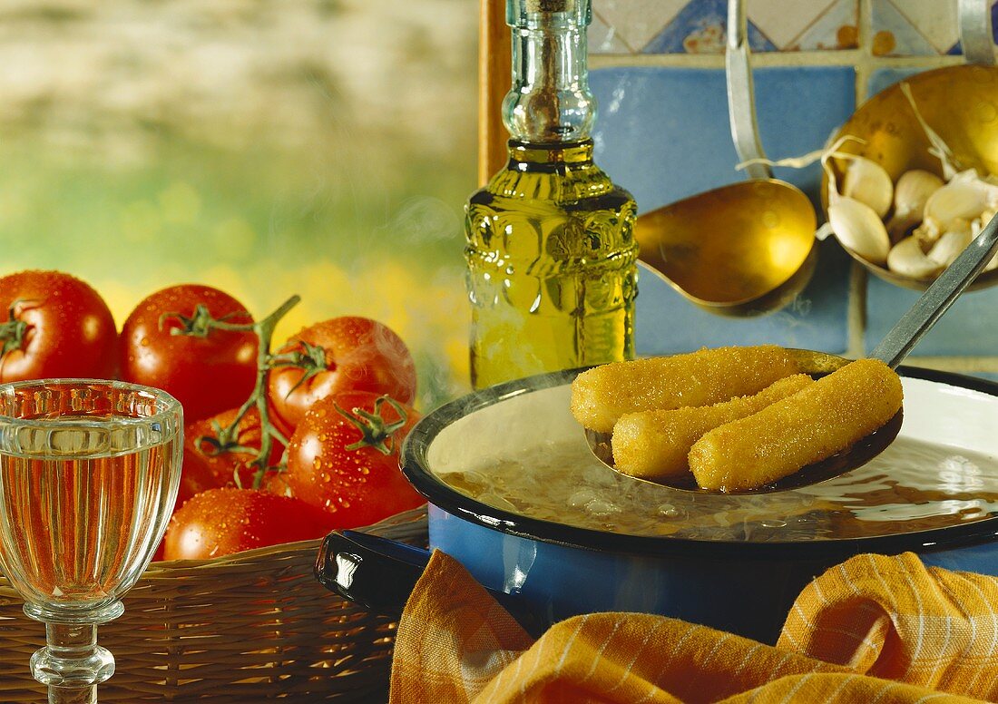 Deep-fried fish croquettes, fresh tomatoes, glass of white wine