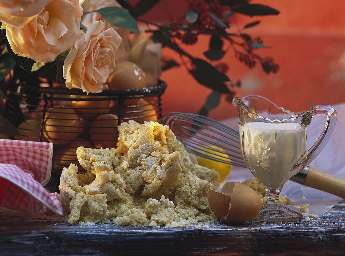 Stillleben mit Teig,Eiern,Glaskännchen mit Milch & Schneebesen