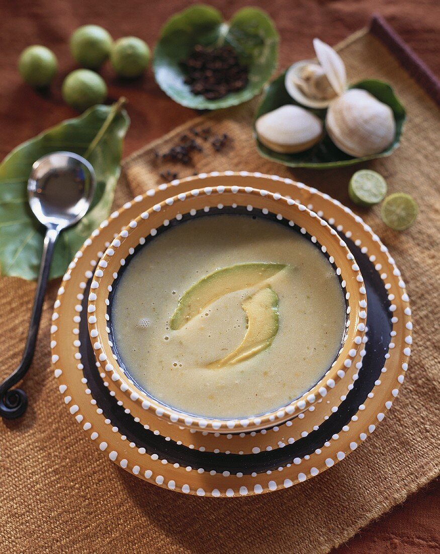 Avocado cream soup with avocado slices and clams