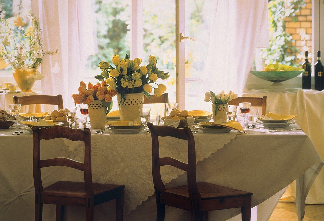 Festlich gedeckter Ostertisch mit Blumen, Eiern, Wein