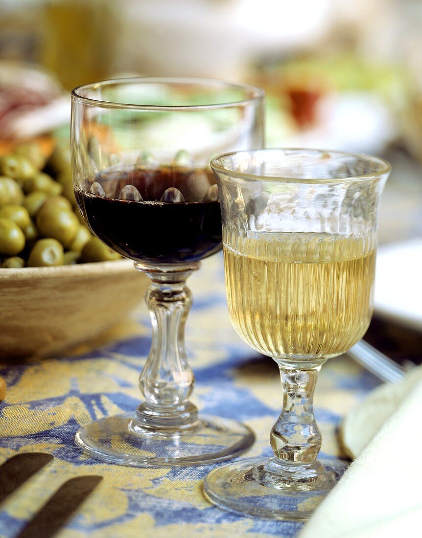 Two rustic glasses with red and white wine