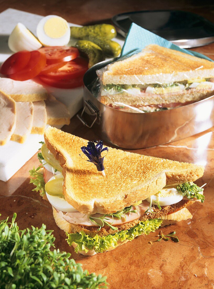Club sandwich with ham, eggs, gherkin and lettuce