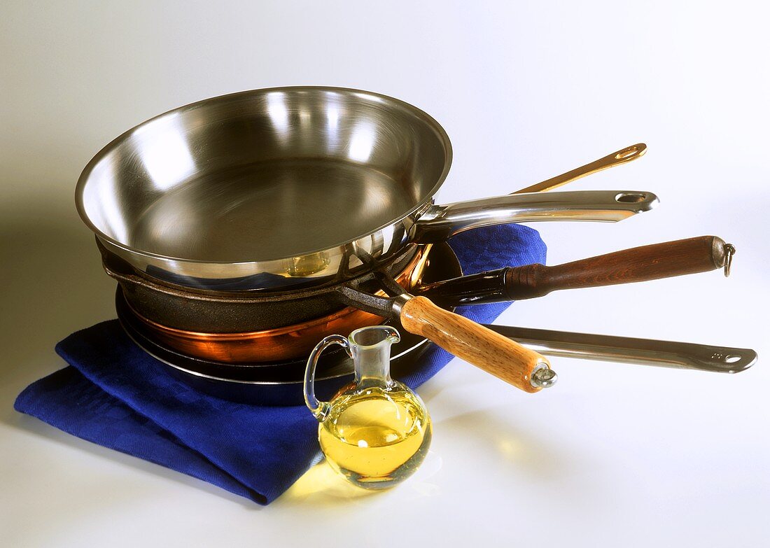 Various frying pans and a small pot of oil