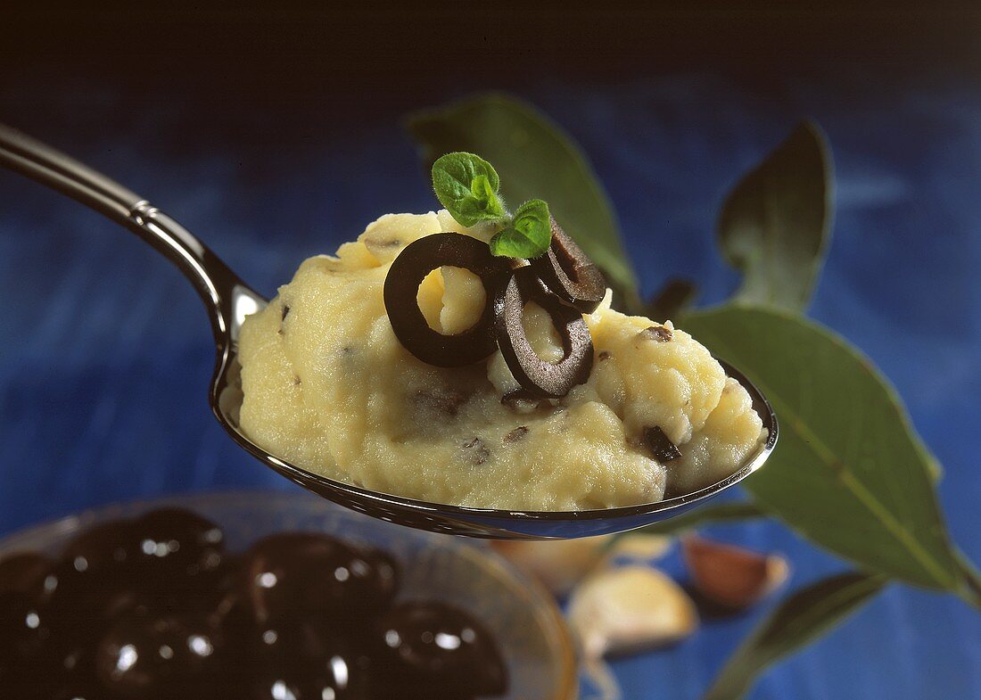 A spoonful of Greek mashed potato with black olives