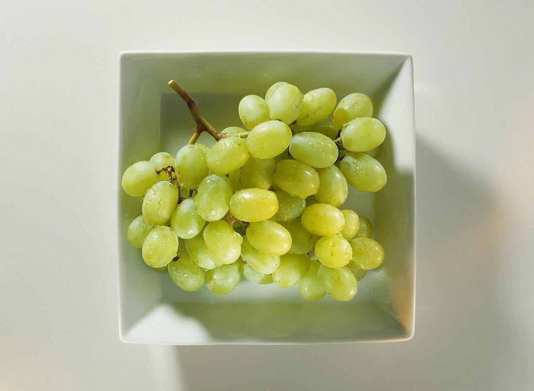 A Bunch of Green Grapes in a White Dish