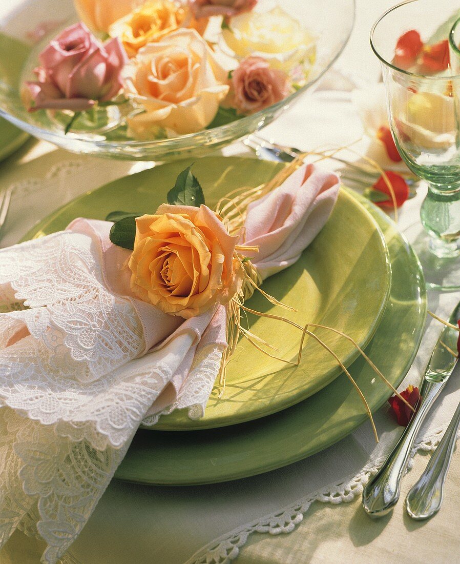 Festliches Gedeck mit grünen Tellern und Rosen