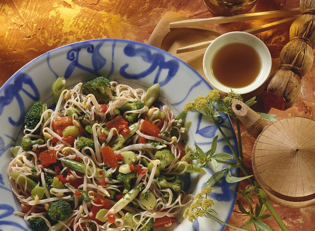 Fried buckwheat noodles with vegetables, tea bowl beside 