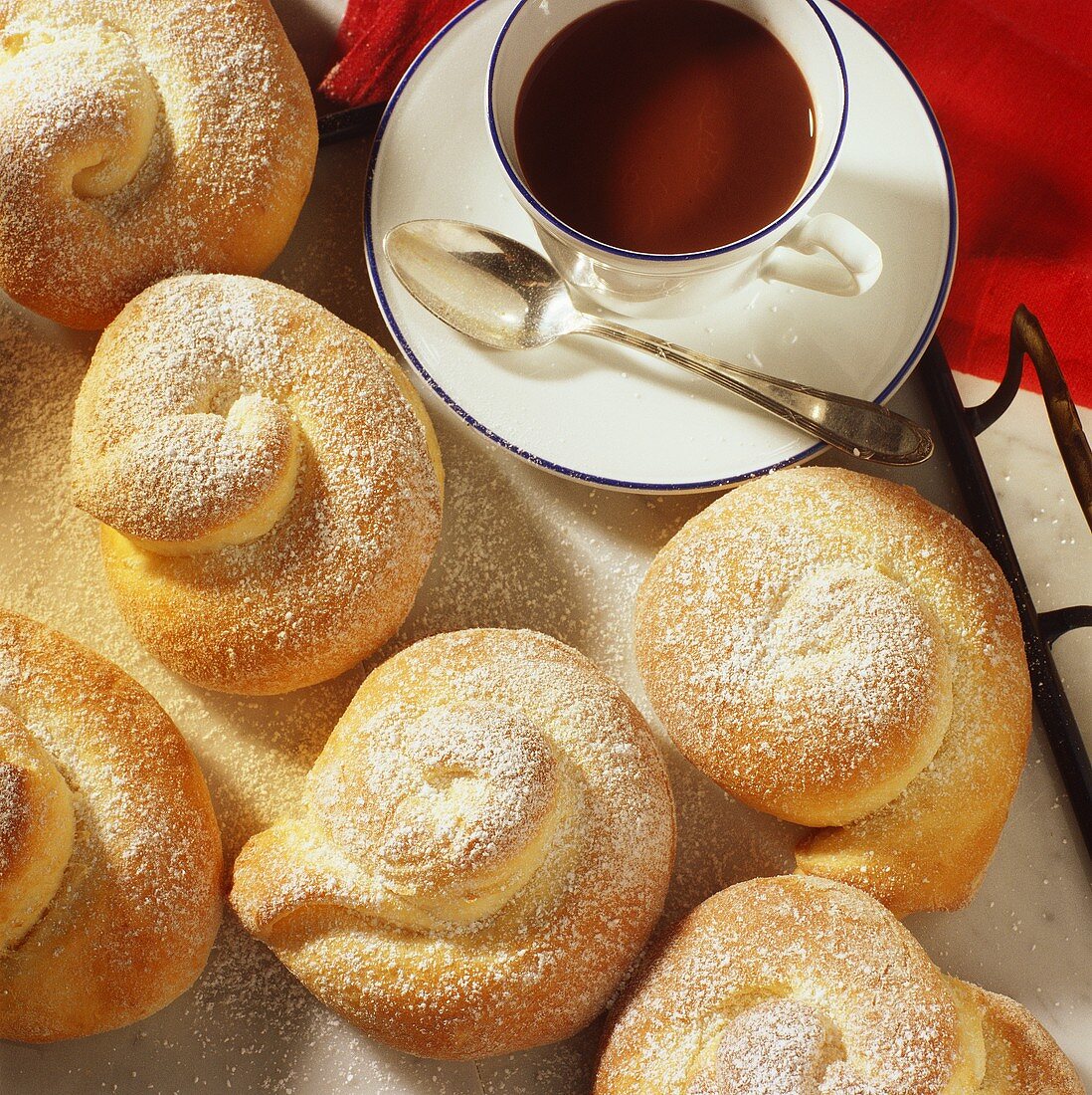 Spanish esmenaldas (yeast pastries) with icing sugar & coffee
