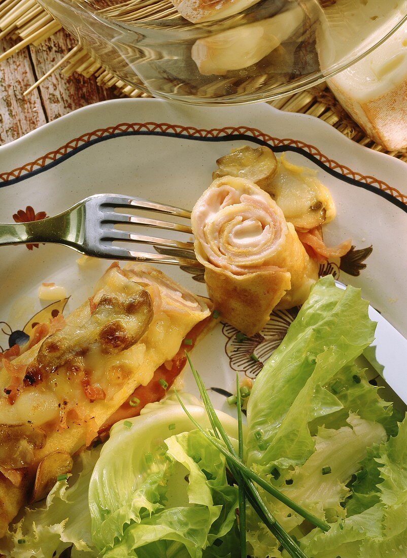 Pancakes with ham and cheese filling, mushrooms, salad