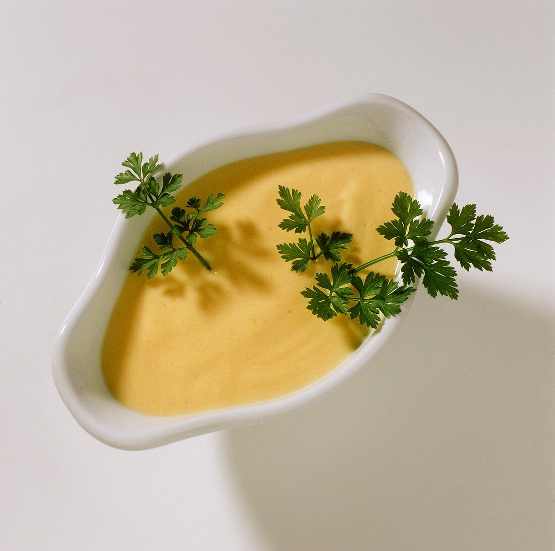 Bowl of mayonnaise sauce and parsley sprigs