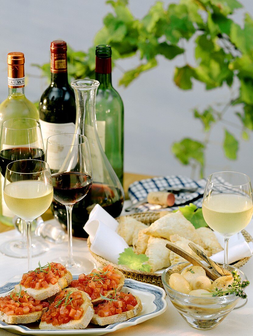 Gedeckter Tisch mit verschiedenen Vorspeisen, Weiß-, Rotwein