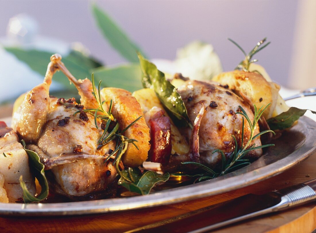 Quail with bacon, celery, white bread, herbs on skewer
