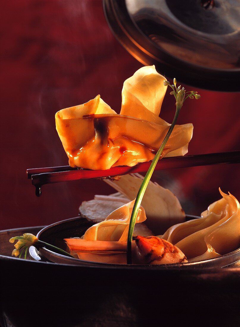 Gefülltes Wan Tan (Teigtäschchen) auf Stäbchen mit Sojasauce