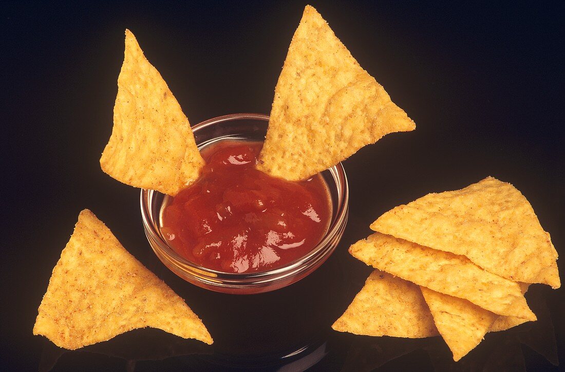 Tortilla Chips on a Black Background with Dish of Salsa