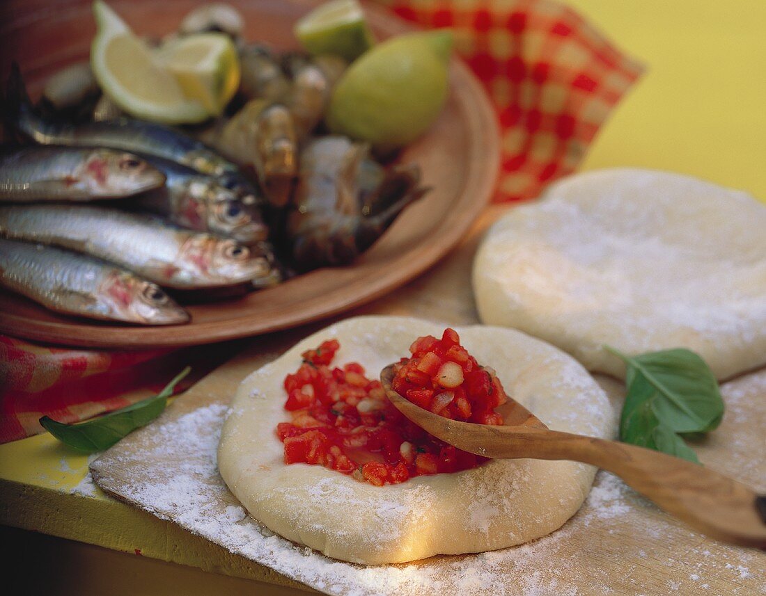 Fisch-Meeresfrüchte-Teller & Pizzateig mit Mehl & Tomaten