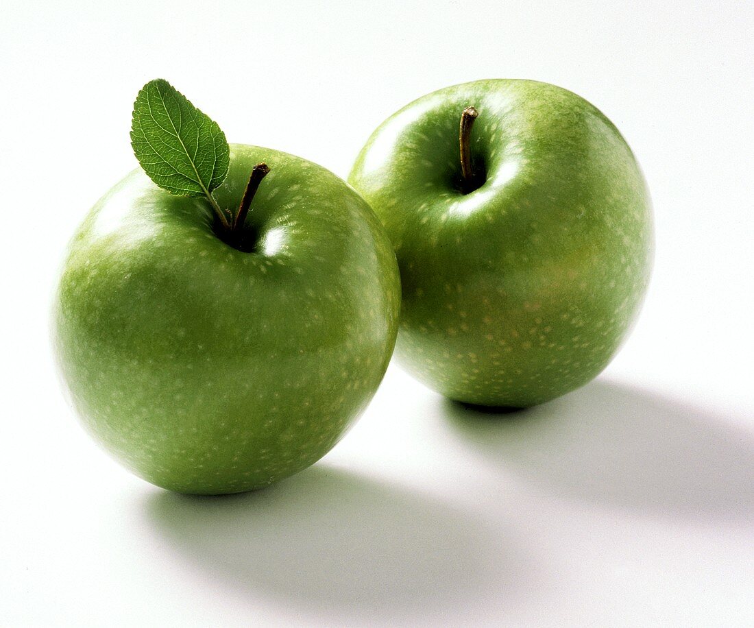Two Granny Smith Apples; One with Leaf