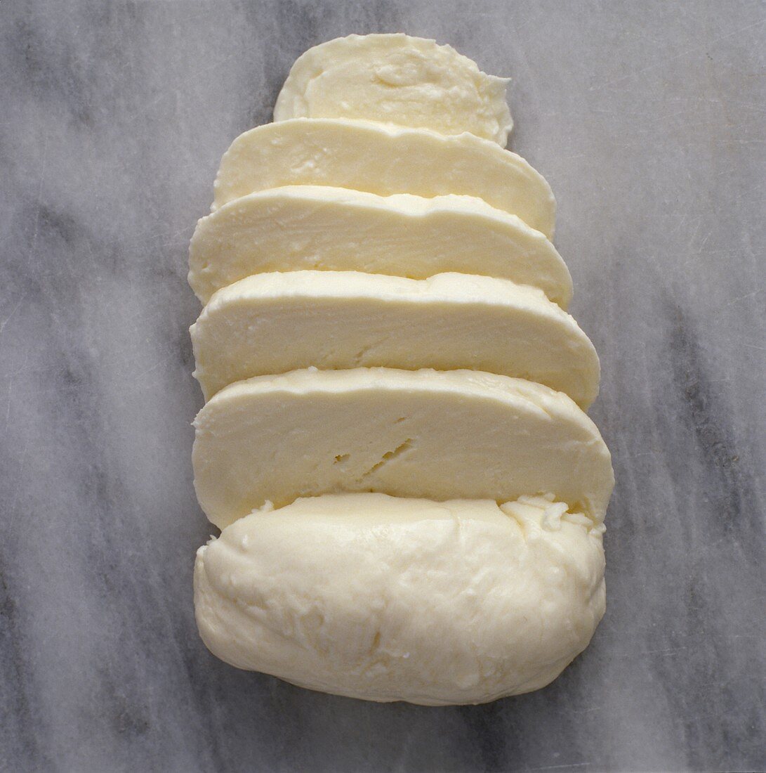 Mozzarella, in Scheiben geschnitten, auf Marmoruntergrund