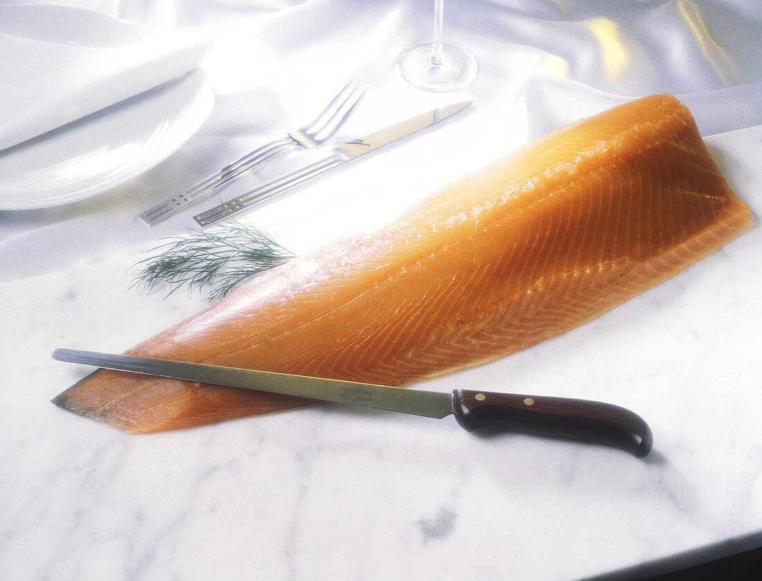 Eine Seite geräucherter Lachs mit Messer, Dillzweig