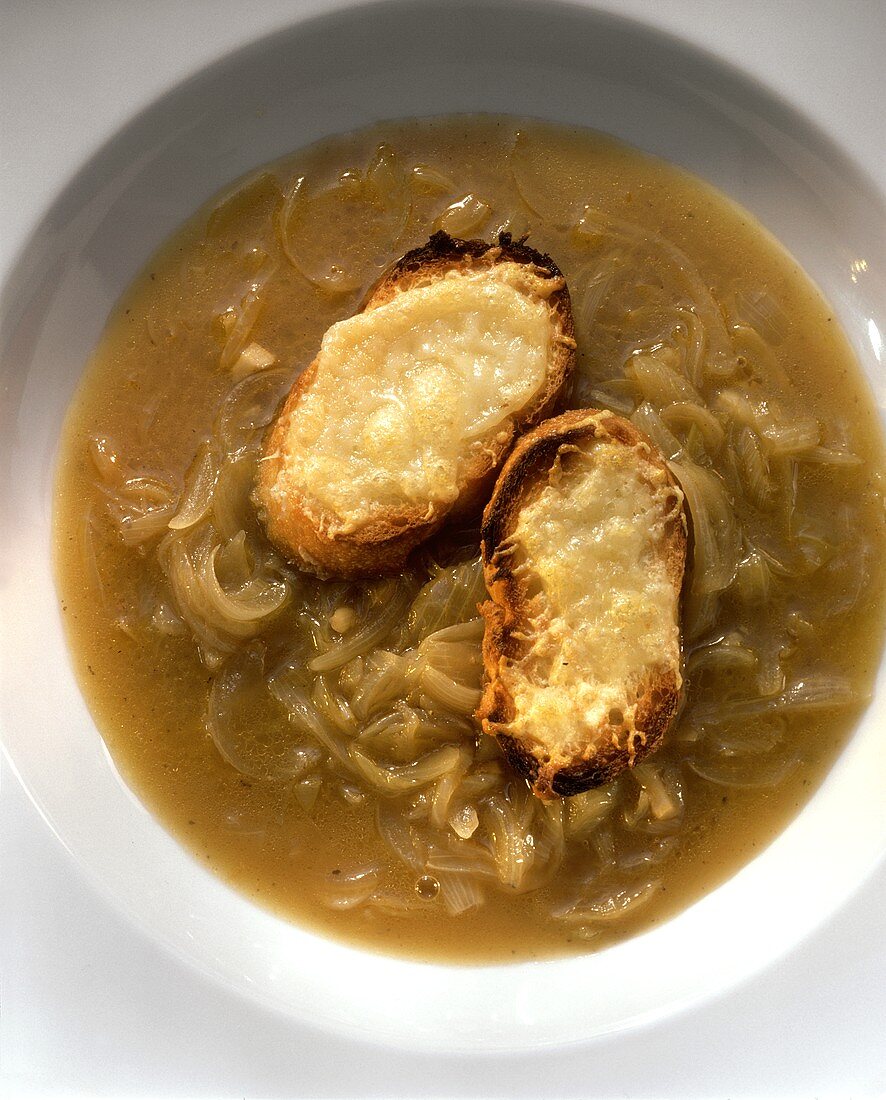 Zwiebelsuppe mit zwei mit Käse überbackenen Brotscheiben