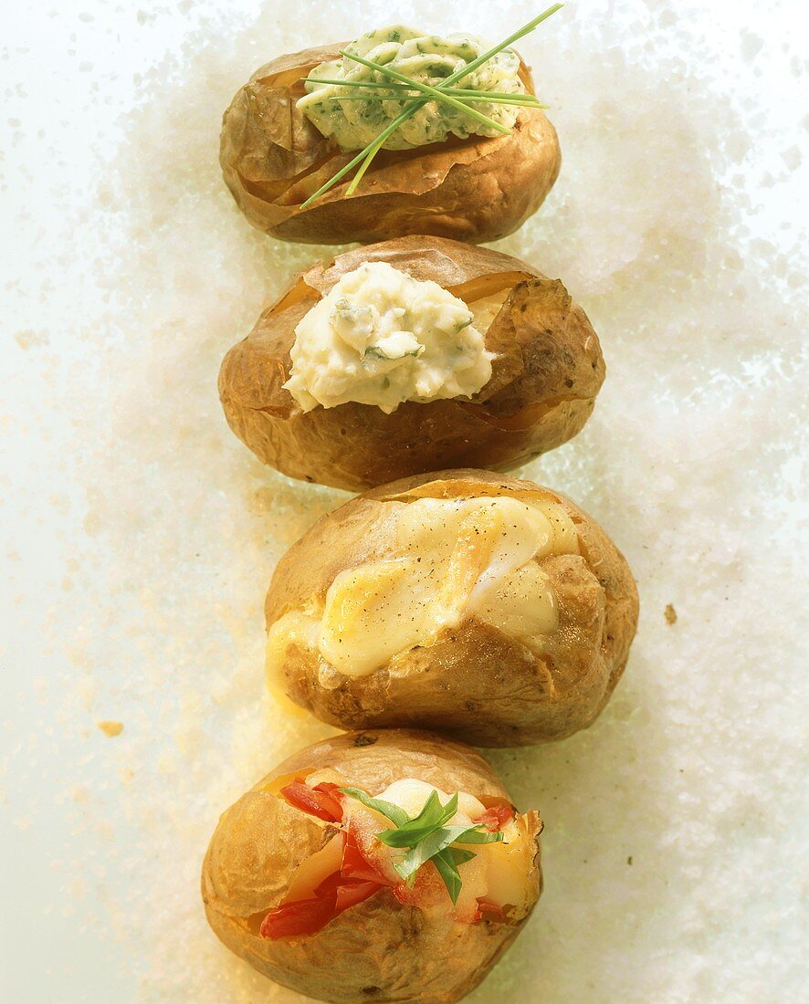 Baked potatoes with various fillings on bed of salt