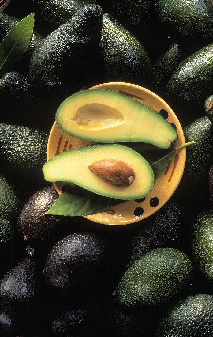 Avocados, plate with two avocado halves on top