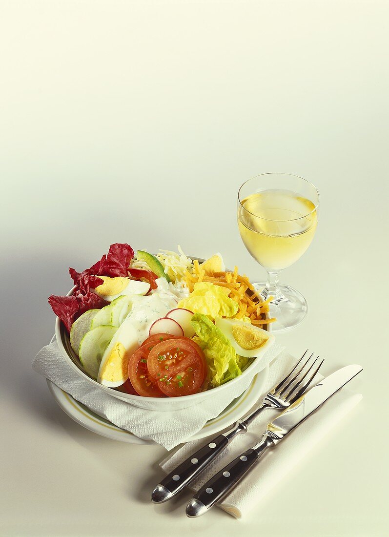 Salad bowl with salad leaves, vegetables, boiled eggs, cheese