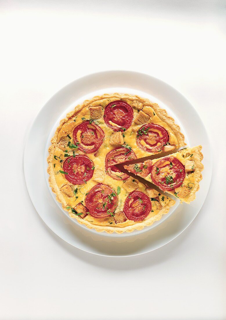 Quiche with tomatoes and soya meat, one piece cut out