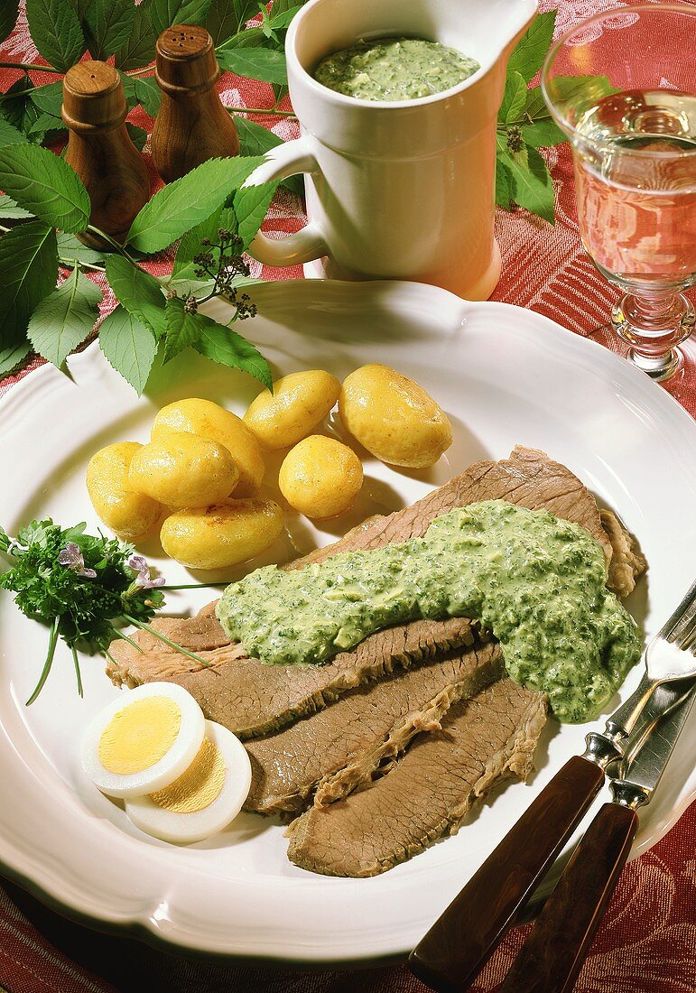 Beef with herb egg sauce and potatoes in their skins