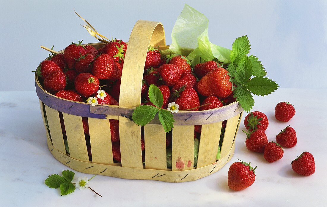 Fresh strawberries with a few leaves in a chip basket