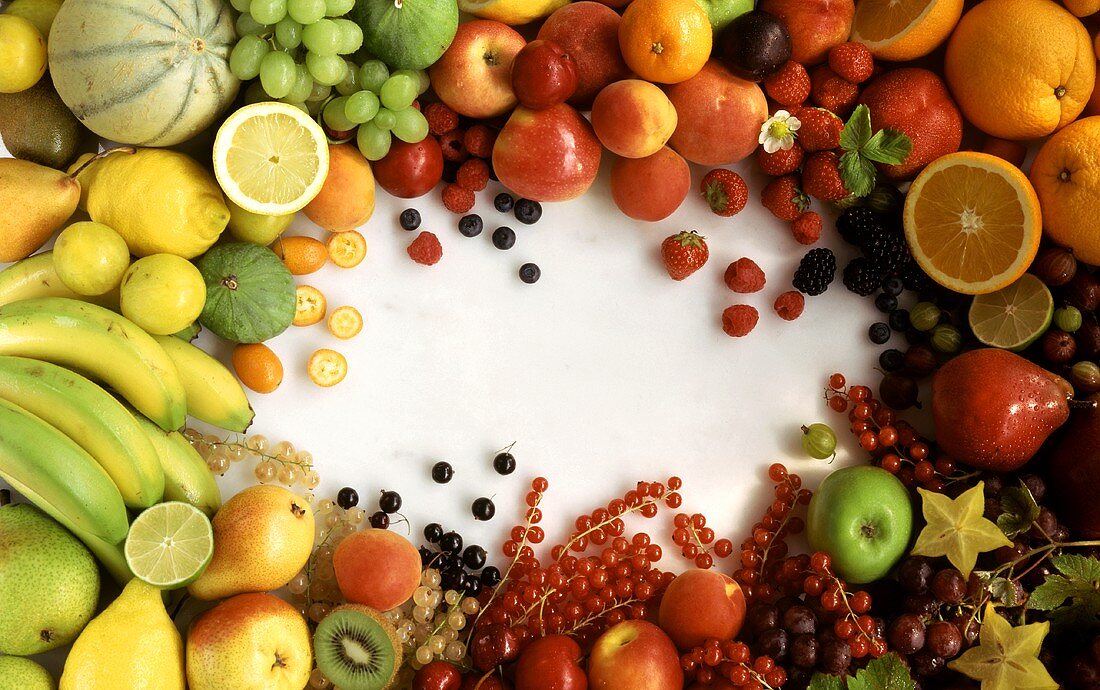 Many different types of fruit arranged round edge of picture