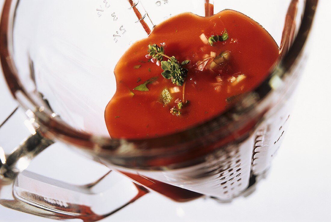 Gazpacho (cold vegetable soup) with herbs in measuring jug