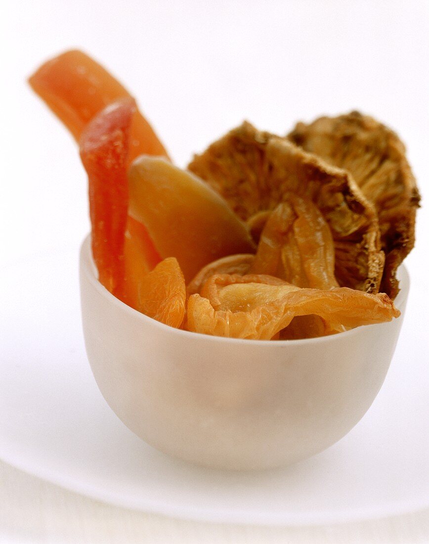 Various dried fruits in white plastic bowl