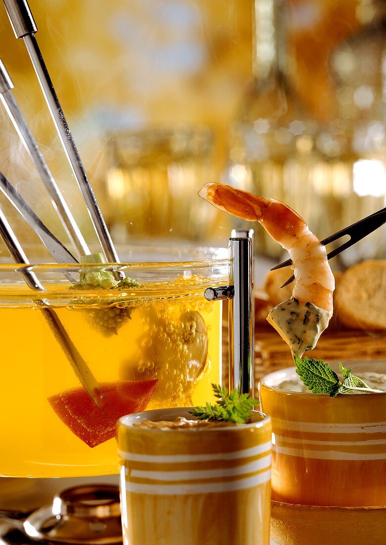 Fondue with vegetables, shrimp on fondue fork & two dips