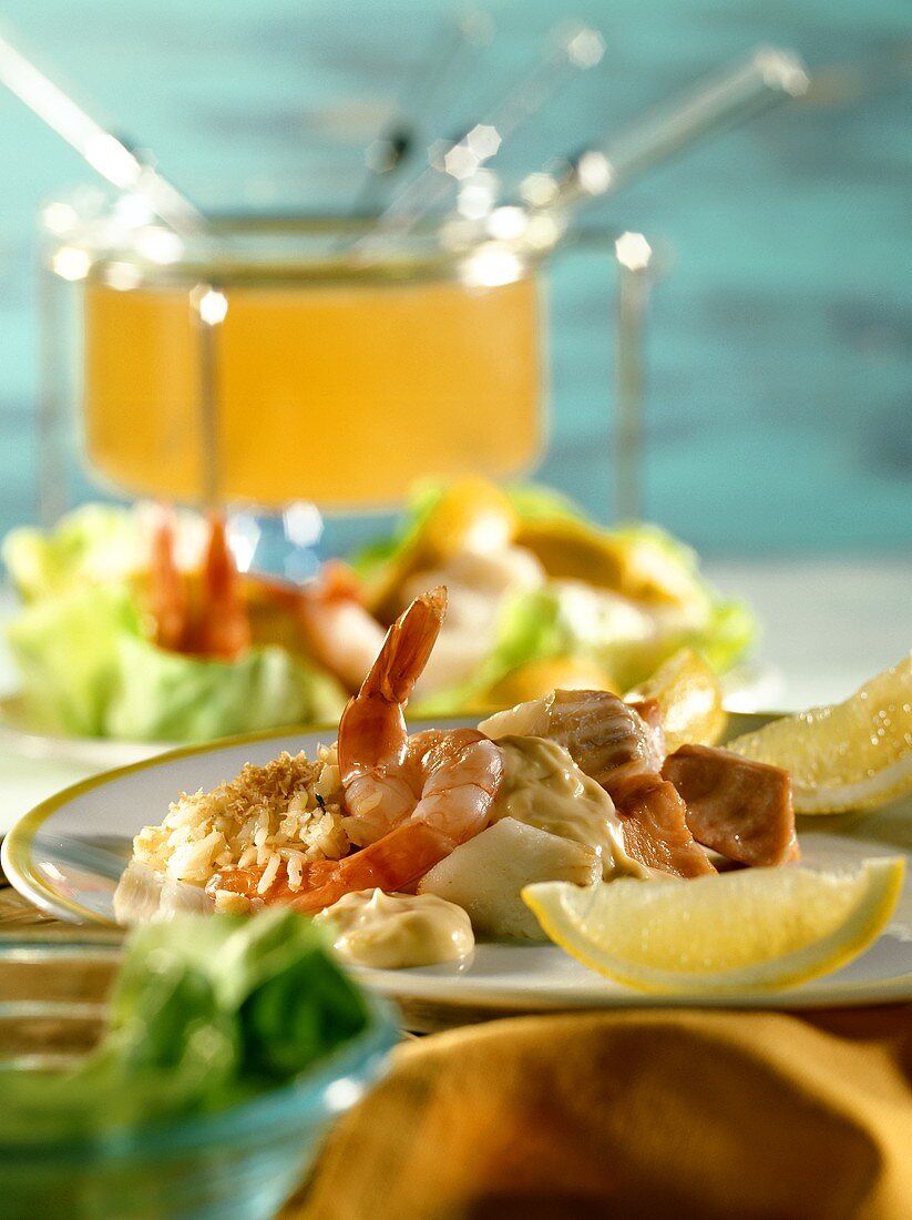 Wine fondue with fish, shrimps and coconut rice on plate
