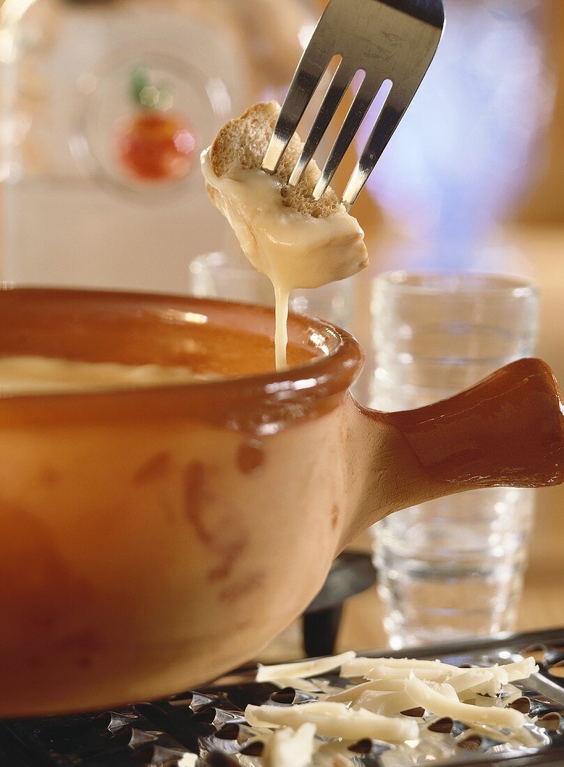 Vaudois fondue with piece of bread on fork above fondue pot