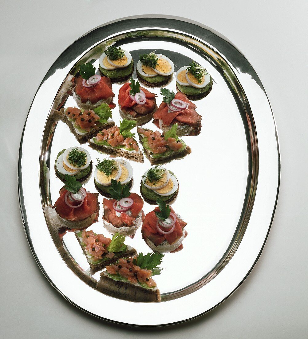 Assorted canapés (roast beef, salmon, egg) on tray