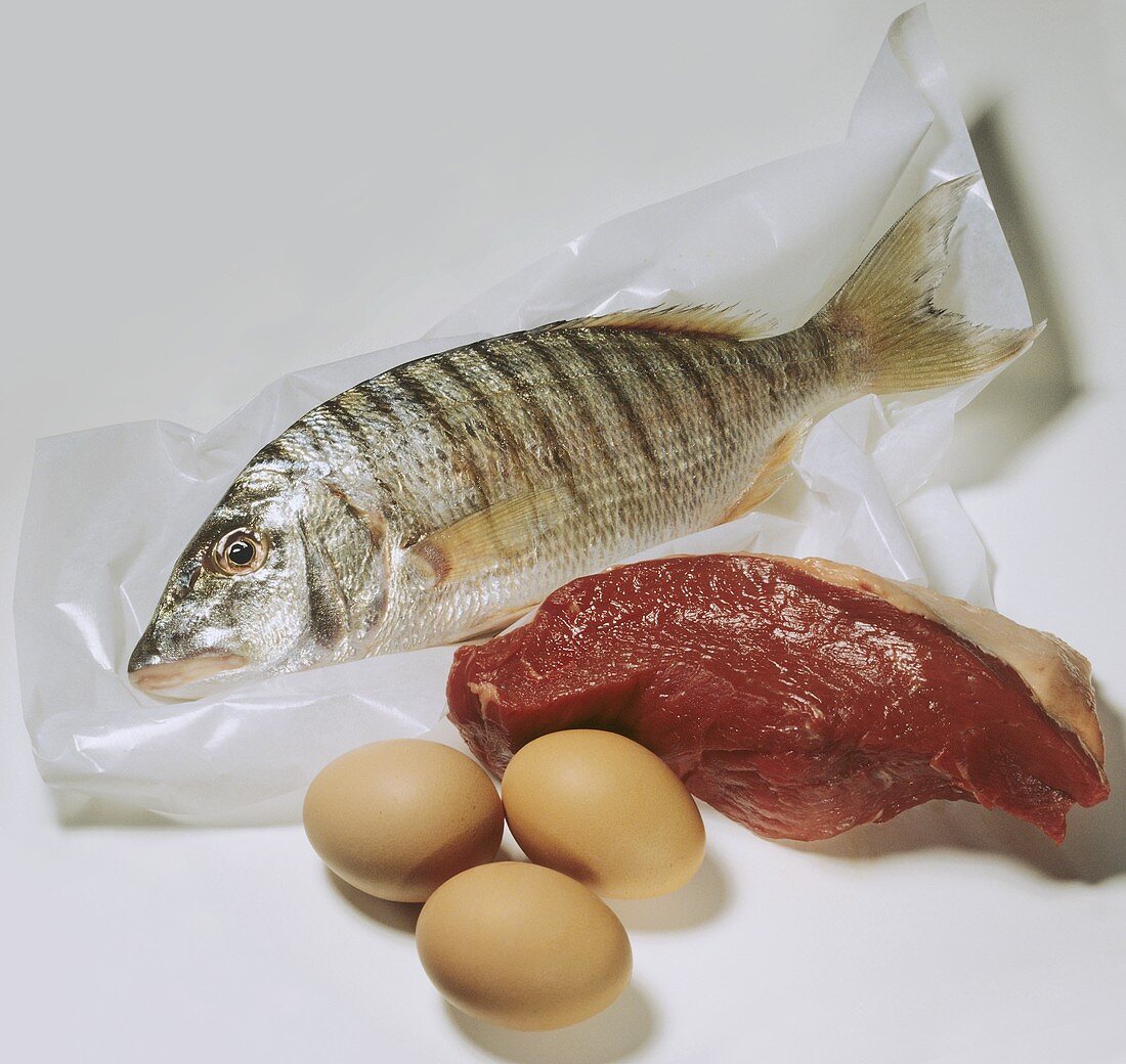 Fish on plastic film, a slice of beef and three eggs