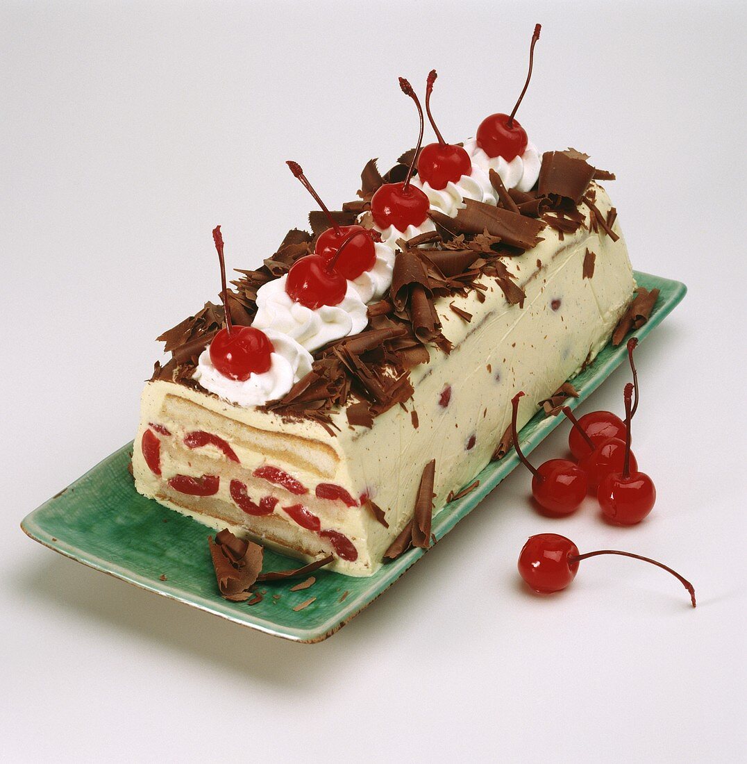 Loaf-shaped cherry ice cream cake, chocolate curls & cherries