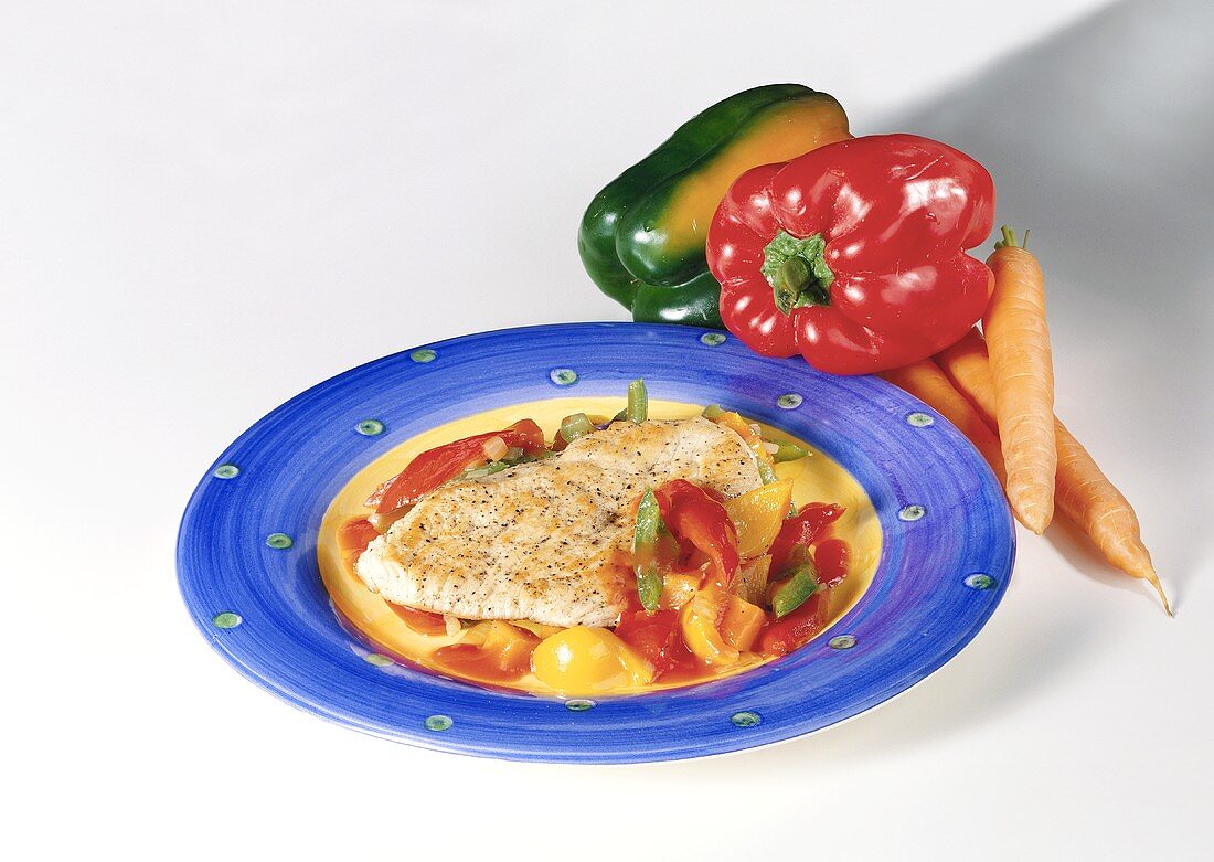 Escalope with pepper sauce on plate; peppers, carrots