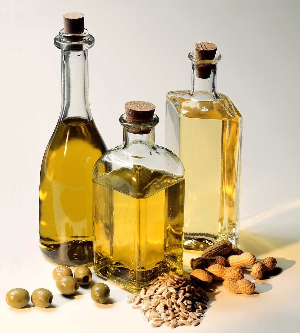 Drei Ölflaschen: Olivenöl, Sonnenblumenöl und Erdnussöl