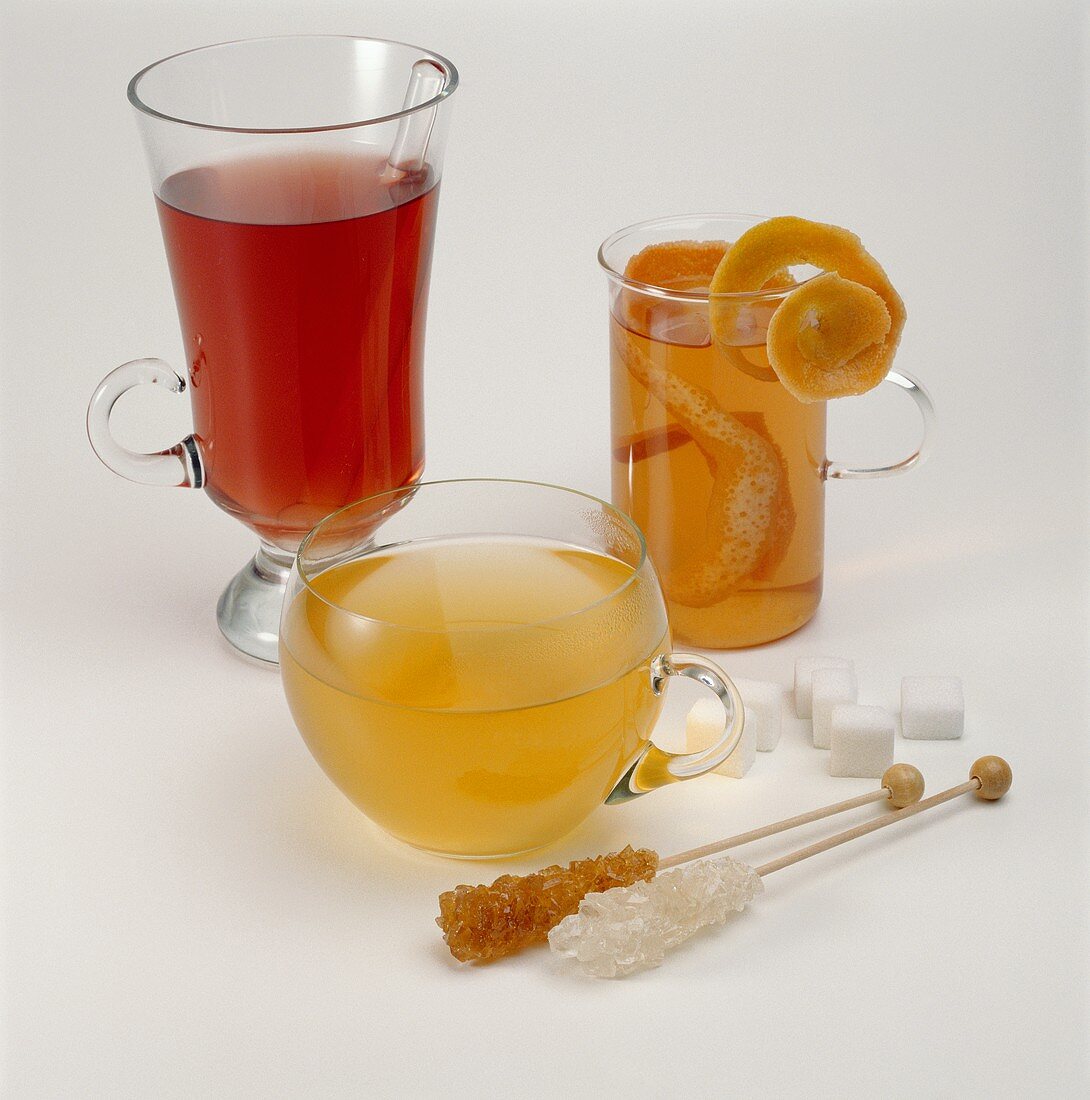 Various teas in glasses; sugar crystals and sugar lumps
