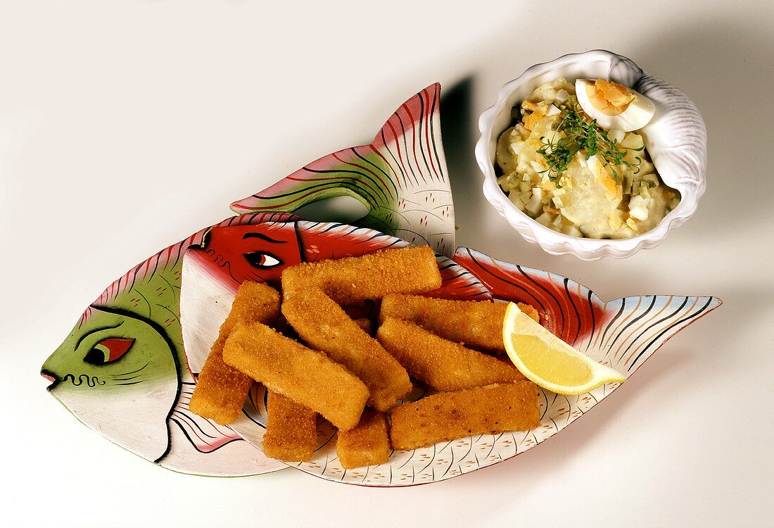 Fish kebab on fish plate and potato salad with egg