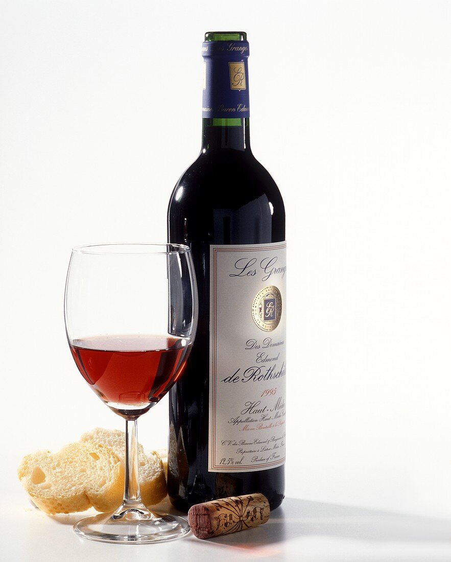 A bottle of red wine (Rothschild), red wine glass, white bread